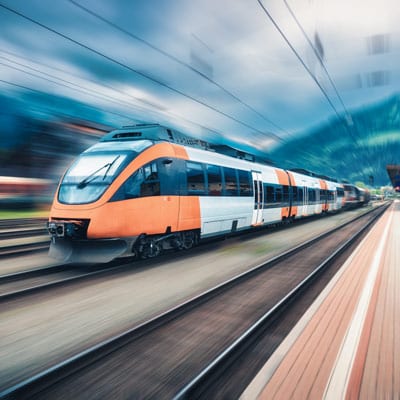 Ein schneller Zug fährt durch einen Bahnhof