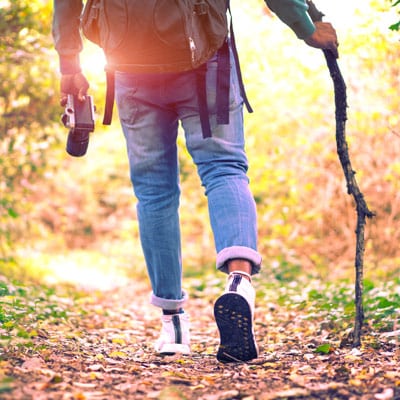 Ein Wanderer in einem Wald mit einer Kamera