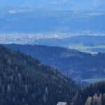 Gasthof Loisebauer an der Zufahrtsstraße zur Simonhöhe, mit eindrucksvollen Bergpanorama und der Stadt Klagenfurt im Hintergrund