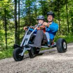 Vater und Kind bei einer abenteuerreichen Fahrt mit den Mountaincarts durch kühle Wälder